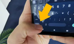Żółta strzałka wskazuje na klawiaturę telefonu, na znak "<".