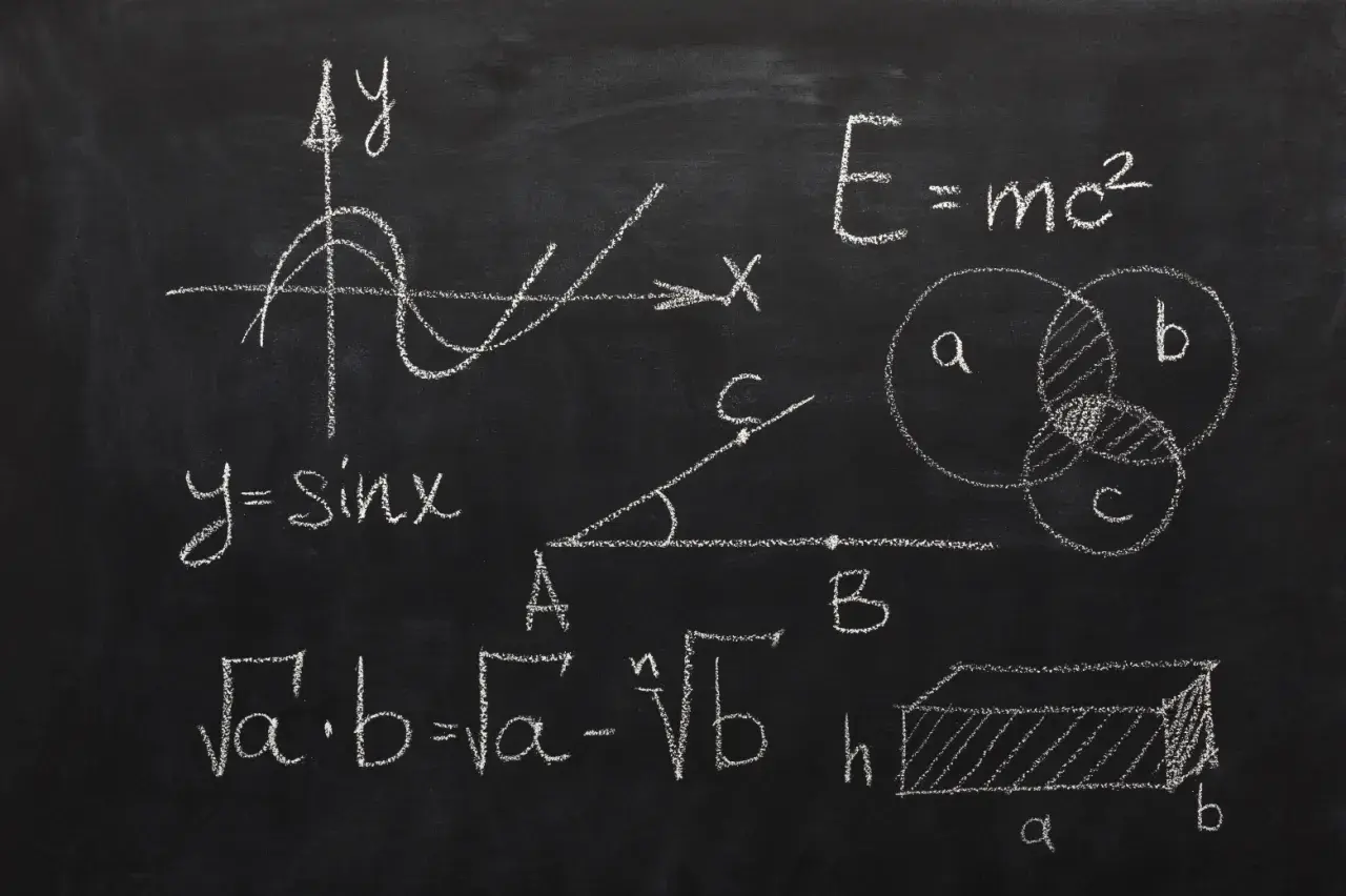 Rysunki matematyczne na tablicy: wykres funkcji sinus, wzory, diagramy Venna, bryła.